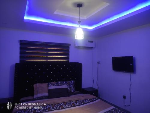 a purple room with a bed and a tv at Parandiapartment in Lagos