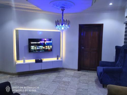 sala de estar con TV de pantalla plana en la pared en Parandiapartment, en Lagos