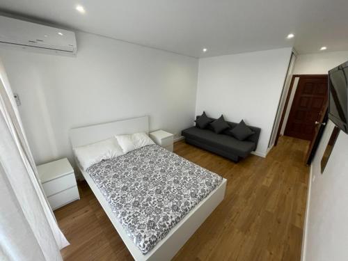 um pequeno quarto com uma cama e um sofá em Monte Gordo South Pearl Apartment em Monte Gordo