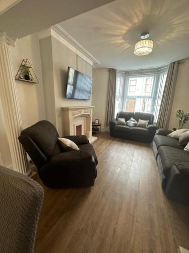 Watford Road House Liverpool في ليفربول: غرفة معيشة مع أريكة ومدفأة