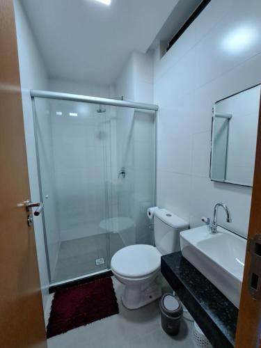 uma casa de banho com um chuveiro, um WC e um lavatório. em Apartamento com piscina no Condominio Maraca2 em Ipojuca