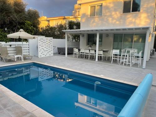 a house with a swimming pool and a patio at Konnos Hight Villa in Protaras