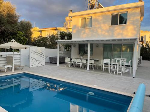 a house with a swimming pool next to a house at Konnos Hight Villa in Protaras