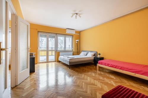ブダペストにあるBpR Castle Point Apartmentの黄色の壁の客室で、ベッド2台が備わります。
