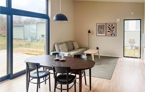 a living room with a table and chairs and a couch at Cozy Home In Jämjö With Jacuzzi in JÃ¤mjÃ¶