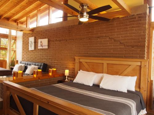 a bedroom with a bed and a brick wall at Casa Mayoral B&B Pet friendly in Valle de Guadalupe