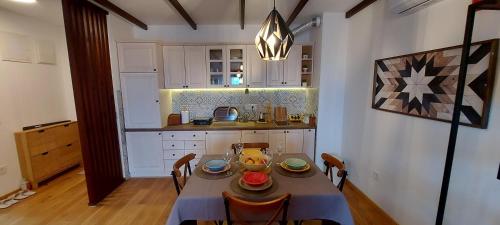 een keuken met een tafel met kommen en borden erop bij Yellow apartman in Vrnjačka Banja