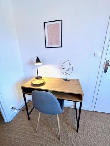 a desk with a chair and a lamp on it at Giena - SILS in Caen