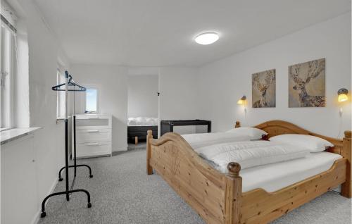 a bedroom with a wooden bed and a dresser at 3 Bedroom Beautiful Home In Bryrup in Bryrup