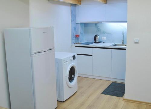a white kitchen with a washing machine and a washer at Guest House Dashi in Gjirokastër