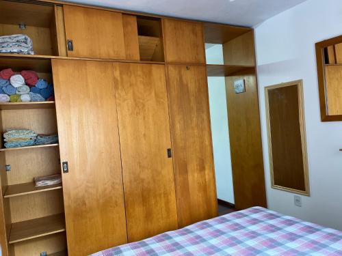 a bedroom with wooden cabinets and a bed at Flat em frente ao Cais Embarcadeiro in Porto Alegre