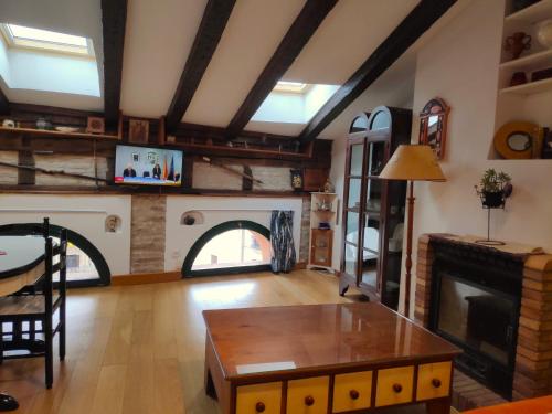 a living room with a fireplace and a table at Atico en la Plaza del ayuntamiento in Pamplona