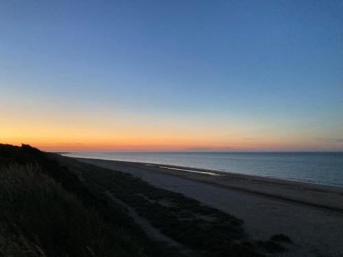 a view of a beach at sunset at Turning Tides Holiday Cottage in Great Yarmouth