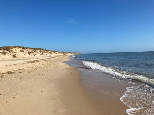a sandy beach with the ocean on a clear day at Turning Tides Holiday Cottage in Great Yarmouth