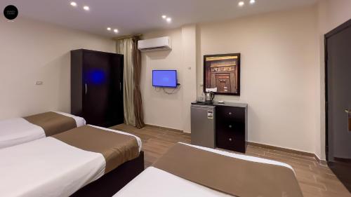 a hotel room with two beds and a tv at Giza Pyramids View Inn in Cairo