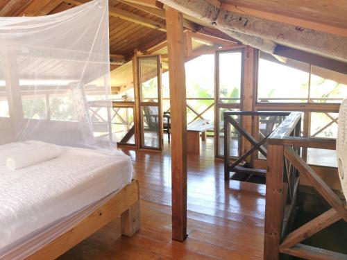 a bedroom with a bed with a net in it at Mango Bottom Jackson Trace in Castara