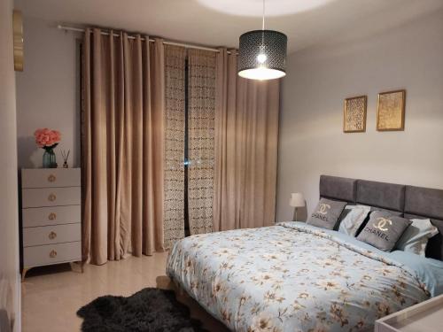 um quarto com uma cama e uma grande janela em Walk to the Beach, Charming 3-Bedroom Home in Ajman Corniche Residences em Ajman
