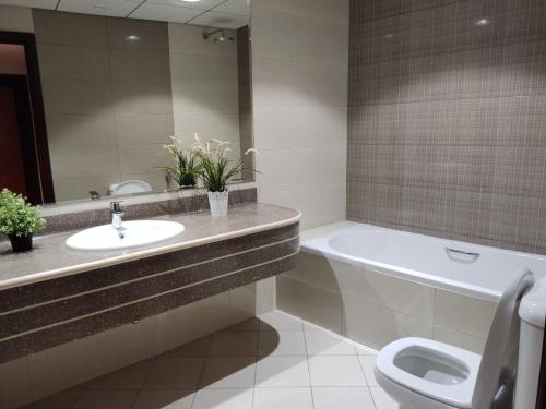 łazienka z umywalką, wanną i toaletą w obiekcie Walk to the Beach, Charming 3-Bedroom Home in Ajman Corniche Residences w mieście Adżman