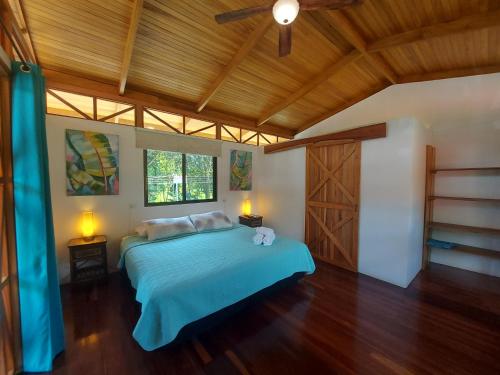 a bedroom with a bed and a wooden ceiling at Ibiza Tropical Beach Villas in Uvita
