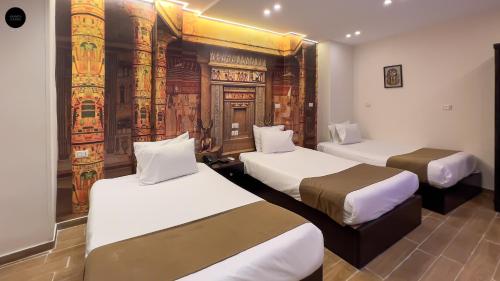 a hotel room with two beds and a mural at Giza Pyramids View Inn in Cairo
