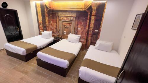 a room with two beds in a room with a wall at Giza Pyramids View Inn in Cairo