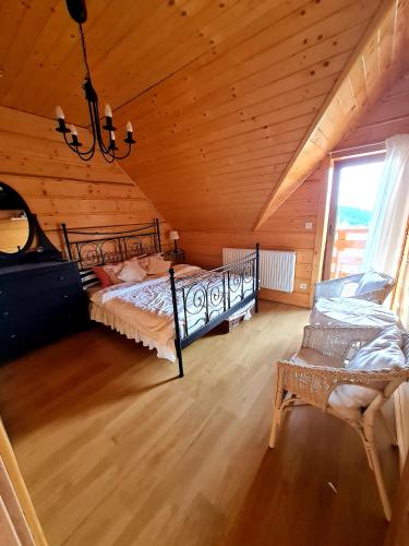 a attic room with two beds and a chandelier at Gorczańska Chata z tarasem widokowym in Poręba Wielka