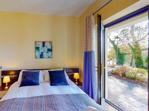 1 dormitorio con 1 cama y puerta corredera de cristal en Grove Lodge No 8 2 Bed, en Killorglin