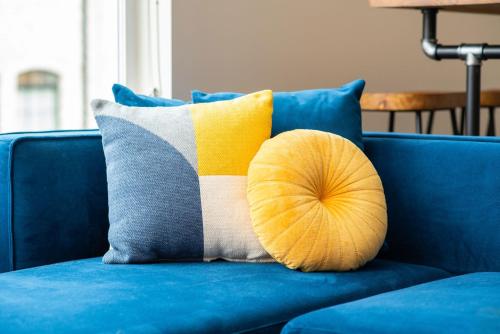 a pillow on a blue couch with a blue couch at Mason Lofts at West End in Nashville