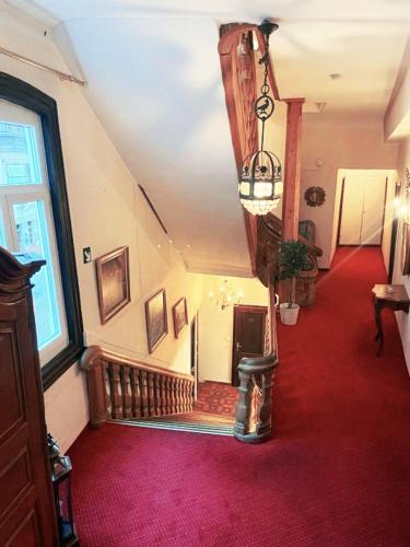 a hallway with a red carpet and a stair case at Hotel zum Goldenen Löwen in Sankt Goar
