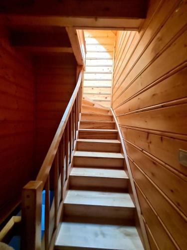 a staircase in a log cabin with wooden walls at Gorczańska Chata z tarasem widokowym in Poręba Wielka