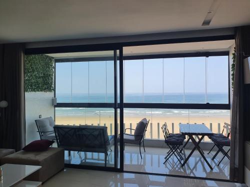 a living room with a view of the beach at La perle de Mehdia, sea view in Kenitra