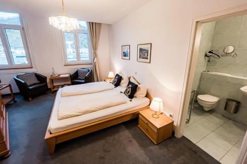 ザンクト・ゴアーにあるHotel zum Goldenen Löwenのベッドルーム1室(ベッド1台付)、バスルーム(シャワー付)が備わります。