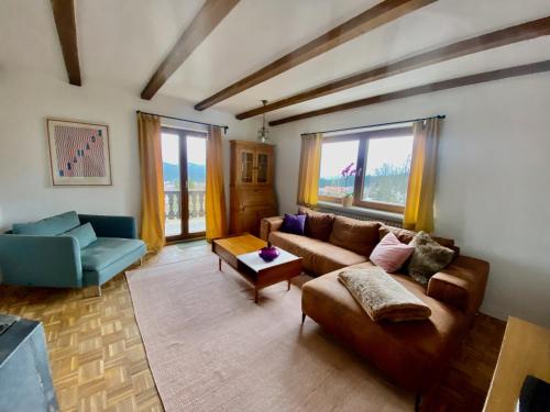 a living room with a couch and chairs and windows at Am Kaisersteig in Zwiesel