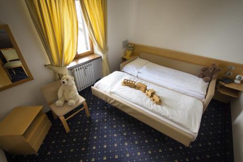 a bedroom with a bed with a teddy bear on it at Hotel Monzoni - San Pellegrino in Passo San Pellegrino