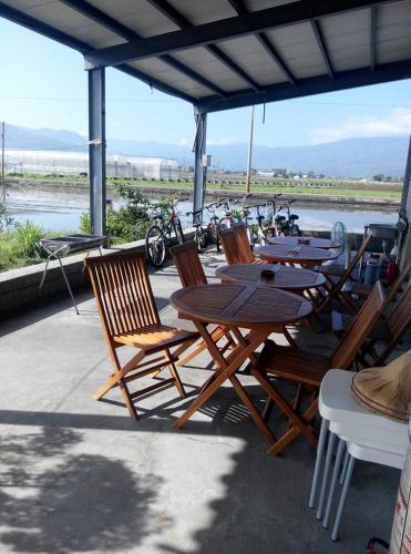 a group of wooden tables and chairs on a patio at Balishanan Homestay in Gongzhao