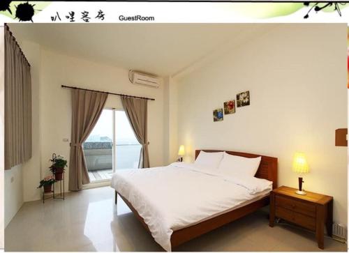 - une chambre avec un grand lit blanc et une fenêtre dans l'établissement Balishanan Homestay, à Gongzhao