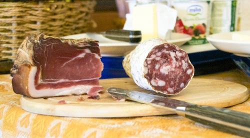 a piece of meat on a cutting board with a knife at Casa Del Noce in Rovereto