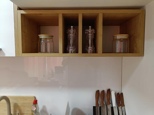 a wooden cabinet with three glass containers on it at Korzo Apartment in Bijelo Polje