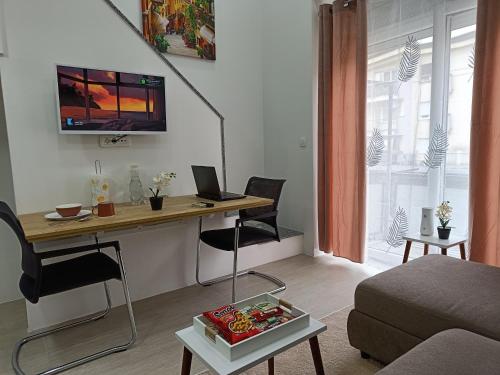 a living room with a desk with a laptop on it at Korzo Apartment in Bijelo Polje