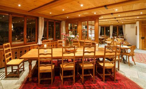 a large wooden table and chairs in a restaurant at Griesalp Hotels in Kiental