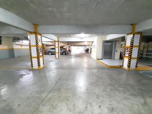 an empty parking garage with yellow and white columns at Paris FC Hotel in Poza Rica de Hidalgo