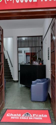 a lobby with a blue ottoman in the middle of a building at Hotel Chalé Da Prata in Curvelo