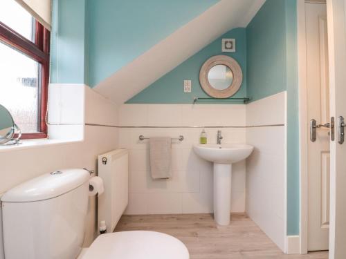 a bathroom with a white toilet and a sink at Grove Cottage in Whitby
