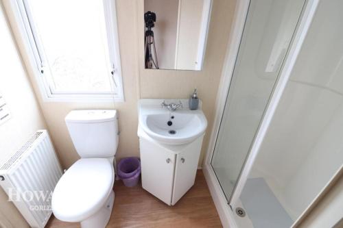 ein Bad mit einem WC, einem Waschbecken und einer Dusche in der Unterkunft 3 bed caravan Norfolk near the coast in Belton