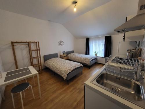 eine Küche mit 2 Betten und einem Waschbecken in einem Zimmer in der Unterkunft Studios idéalement situés - EU in Brüssel