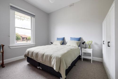 Un dormitorio blanco con una cama grande y una ventana en Ellenora, en Warrnambool