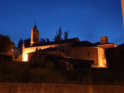 a building with a clock tower at night at Sleeping Sarria in Sarria