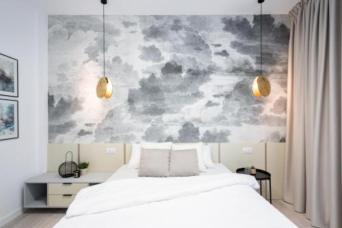 a bedroom with a white bed and a wall mural at FOUR Bedroom Apartment, Old Town Bucharest in Bucharest