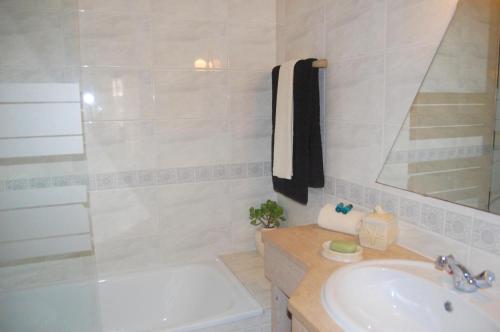 a bathroom with a sink and a tub and a shower at Flat Via Torraltinha in Lagos
