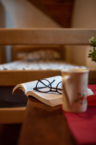 a pair of glasses sitting on a book next to a cup at Rustic Home Tara in Kaludjerske Bare
